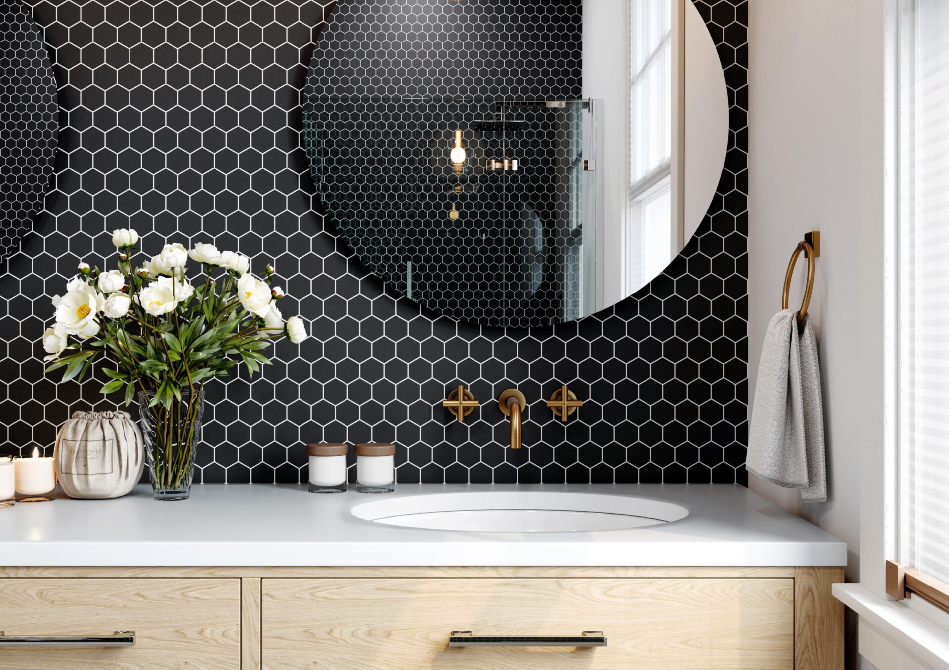 Modern bathroom vanity with black hexagon tile backsplash, gold fixtures, and a round mirror.